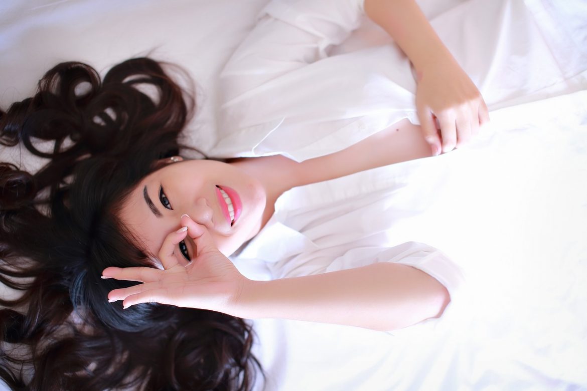 woman with long hair laying in bed
