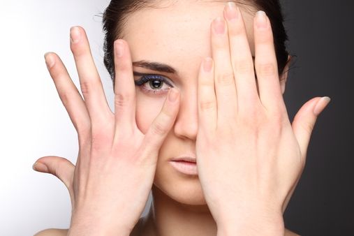 Girl with hands across face
